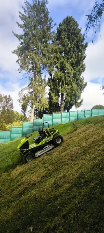 Tonte d'un talus en pente avec une tondeuse autoportée.